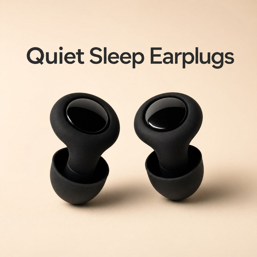 Quiet Sleep Earplugs - two black silicone earplugs with soft ear tips on a warm sand backdrop