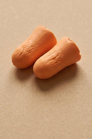 A pair of used orange foam earplugs