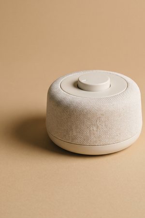 A small round white-noise machine with a single dial